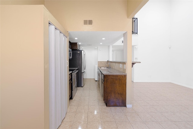 kitchen featuring a sink, light tile patterned floors, visible vents, baseboards, and appliances with stainless steel finishes