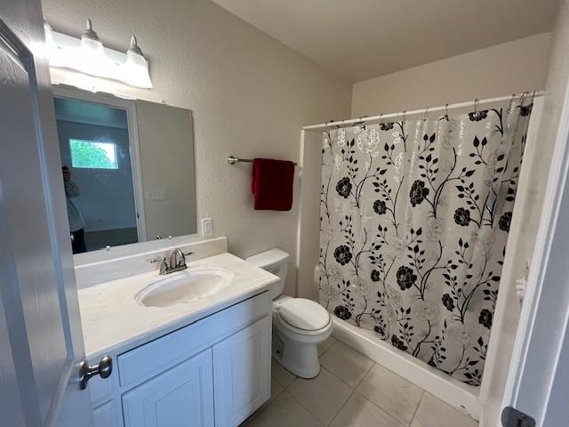 610 N Pecan St, Hico, TX 76457 - full bathroom with toilet, a shower with curtain, tile patterned flooring, and vanity