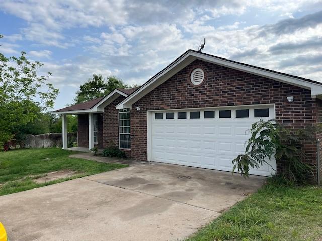 610 N Pecan St, Hico, TX 76457 - ranch-style home featuring a garage, brick siding, a front lawn, and driveway