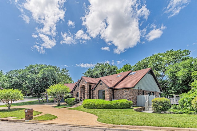 2405 Castle Rock Rd, Arlington, TX 76006 - tudor-style house with brick siding, a front lawn, and a tile roof