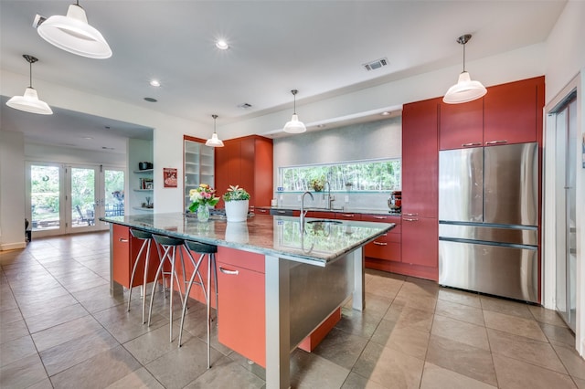 1580 Stemmons Ave, Dallas, TX 75208 - kitchen featuring freestanding refrigerator, plenty of natural light, recessed lighting, a breakfast bar, and dark stone counters