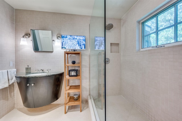 1580 Stemmons Ave, Dallas, TX 75208 - bathroom with tile walls, tiled shower, vanity, and tile patterned floors