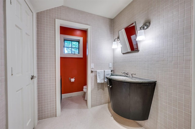 1580 Stemmons Ave, Dallas, TX 75208 - bathroom with toilet, vanity, tile walls, and tile patterned flooring