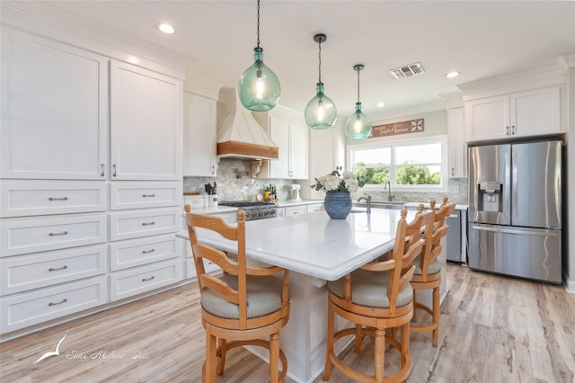 kitchen featuring white cabinetry, a sink, stainless steel appliances, light countertops, and custom exhaust hood
