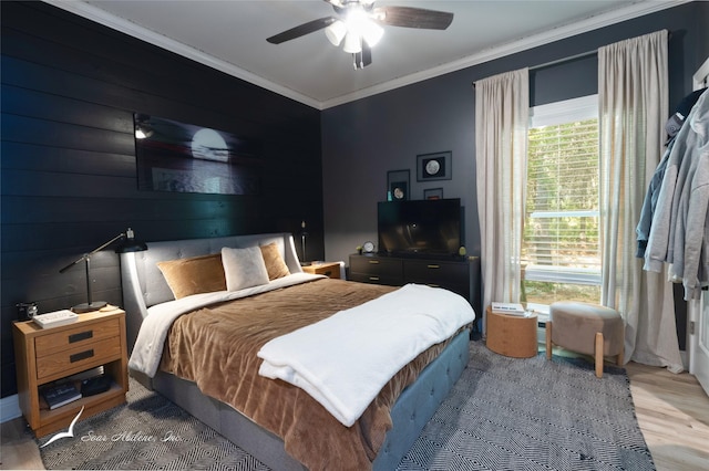 bedroom with wood finished floors, a ceiling fan, and ornamental molding