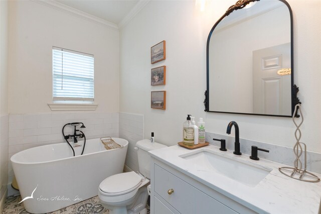 bathroom featuring ornamental molding, toilet, a freestanding tub, and vanity