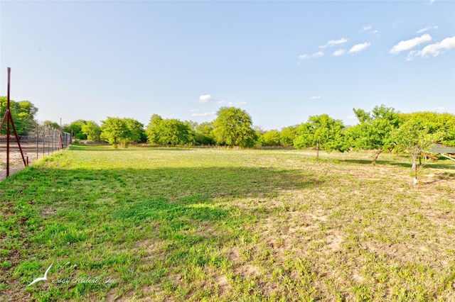 view of yard with fence and a rural view