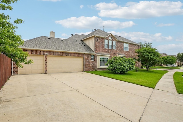 traditional-style home featuring a front yard, a shingled roof, brick siding, concrete driveway, and an attached garage