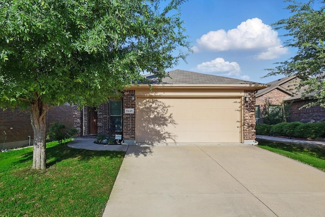 view of front of house with a front yard, driveway, a garage, and brick siding