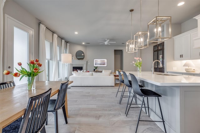 4009 Palomino Rd, Aubrey, TX 76227 - dining room with a ceiling fan, a fireplace, a chandelier, and recessed lighting