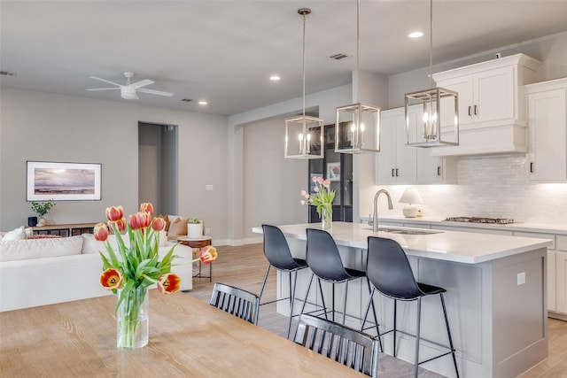 4009 Palomino Rd, Aubrey, TX 76227 - kitchen featuring a sink, light countertops, backsplash, a kitchen bar, and an island with sink