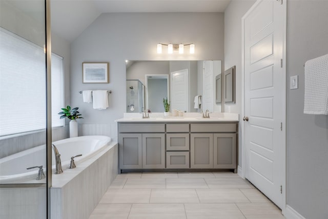 full bath featuring double vanity, vaulted ceiling, a bath, a sink, and a stall shower