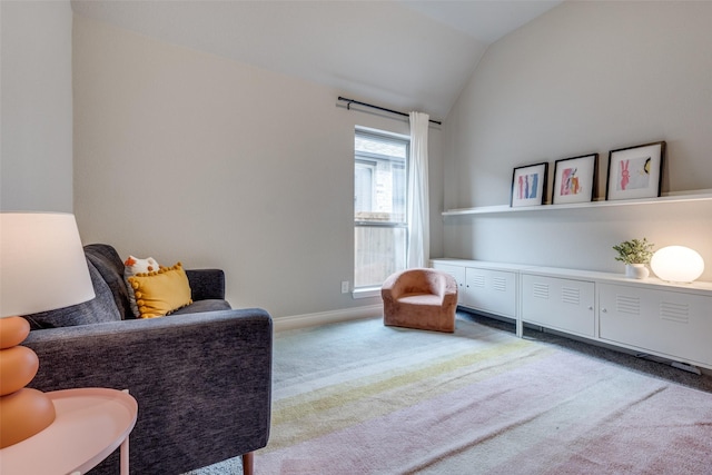 living area featuring lofted ceiling, baseboards, and carpet floors