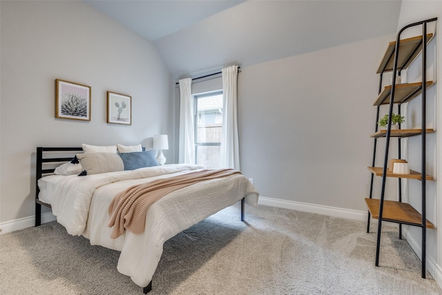 carpeted bedroom with vaulted ceiling and baseboards