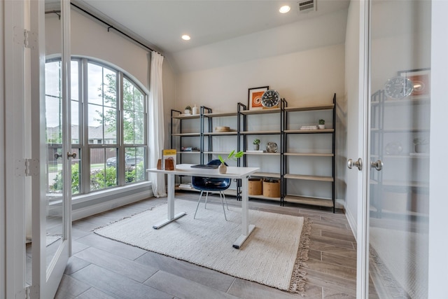 office featuring wood tiled floor, visible vents, french doors, and a healthy amount of sunlight