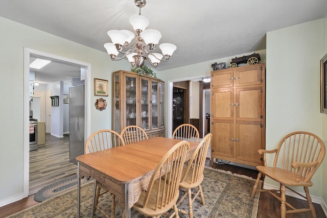 dining room with baseboards, a notable chandelier, and dark wood-type flooring