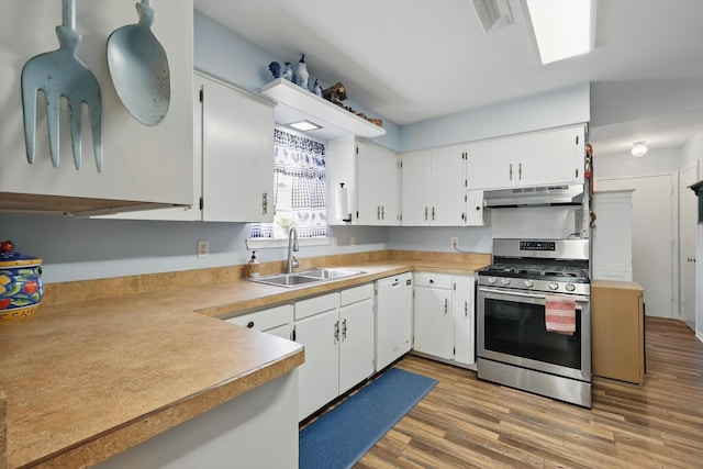 kitchen featuring gas range, under cabinet range hood, dishwasher, light wood finished floors, and a sink