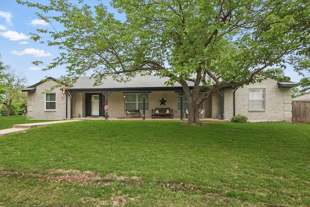 ranch-style home featuring fence, a front yard, and brick siding