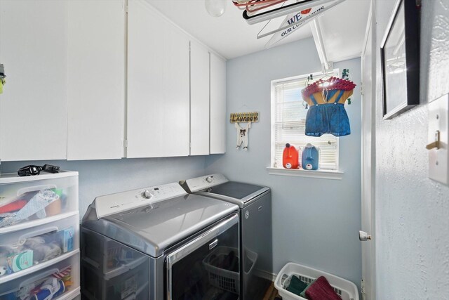 clothes washing area featuring cabinet space and washing machine and dryer