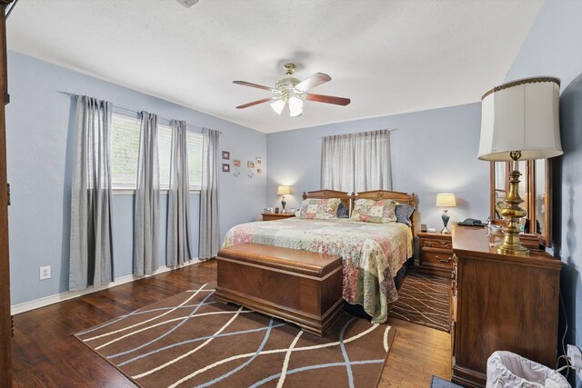 bedroom featuring wood finished floors, a ceiling fan, and baseboards