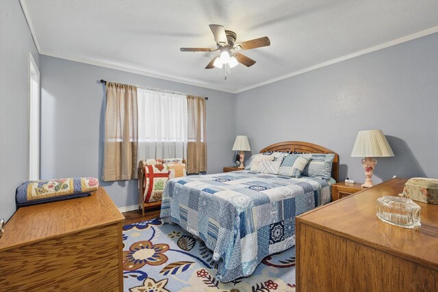 bedroom with wood finished floors, ceiling fan, crown molding, and baseboards