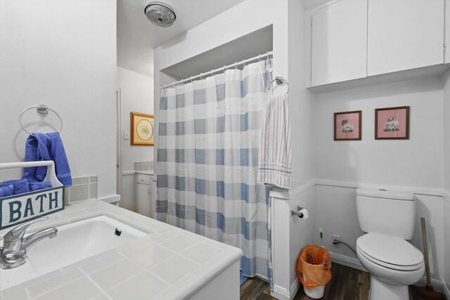 full bath featuring toilet, a sink, wood finished floors, and a shower with shower curtain
