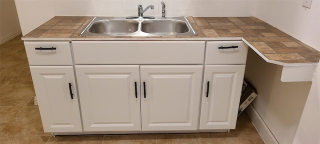 room details featuring white cabinets and a sink