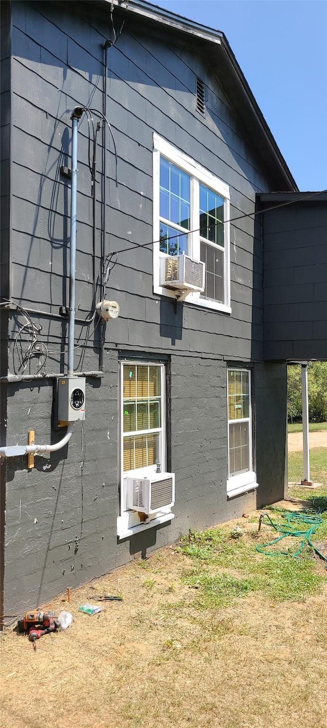 view of side of property featuring cooling unit and a lawn