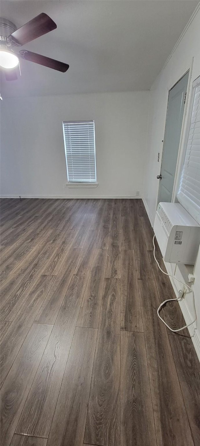 unfurnished room featuring a wall mounted air conditioner, dark wood-style floors, and a ceiling fan
