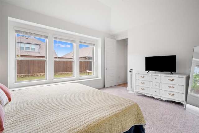 bedroom with baseboards, light carpet, and vaulted ceiling
