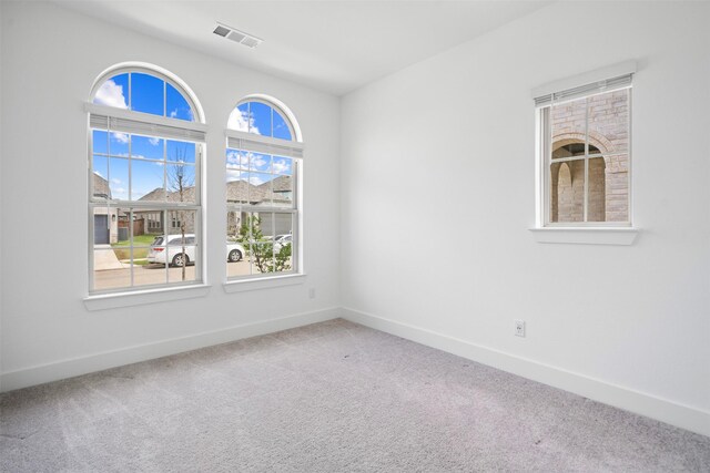 spare room with baseboards, visible vents, and carpet