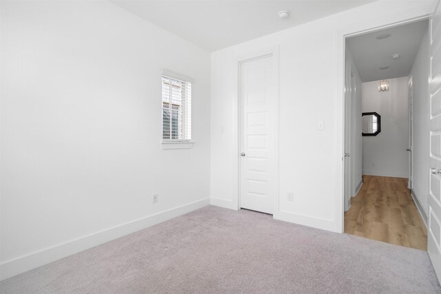 unfurnished bedroom with baseboards and light carpet