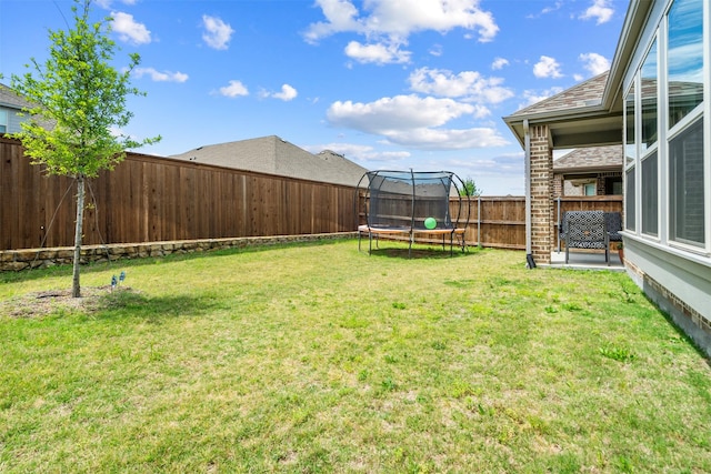 view of yard with a fenced backyard and a trampoline