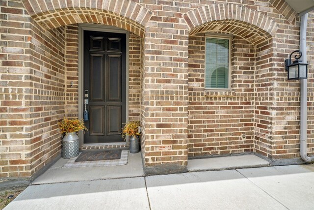 doorway to property featuring brick siding