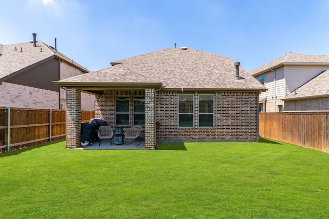 rear view of property with a lawn, a patio area, and a fenced backyard