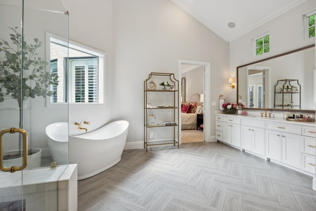 full bathroom featuring crown molding, a freestanding bath, vanity, high vaulted ceiling, and baseboards