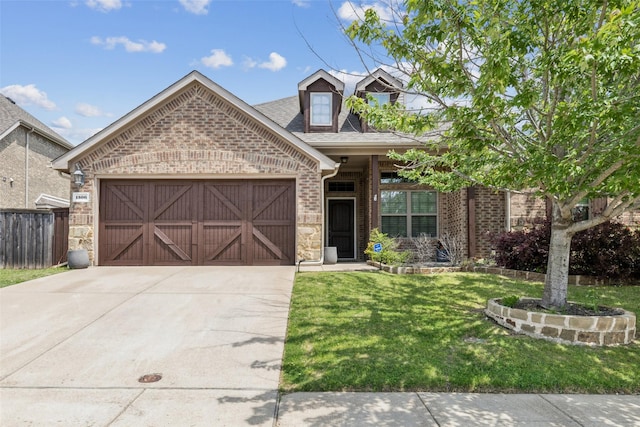 view of front facade featuring concrete driveway, a front yard, fence, brick siding, and a garage