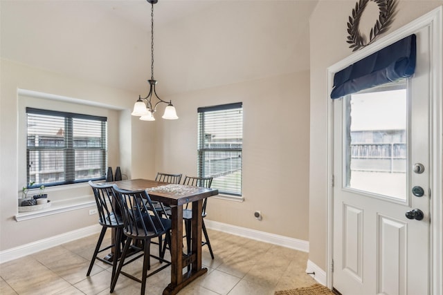 dining space featuring light tile patterned floors, a chandelier, vaulted ceiling, and baseboards