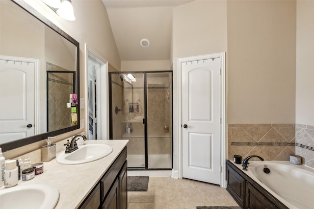 bathroom with vaulted ceiling, a stall shower, a garden tub, and a sink
