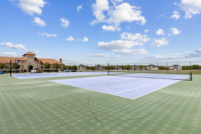 view of tennis court with community basketball court and fence