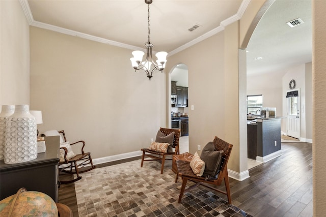 sitting room featuring ornamental molding, arched walkways, and visible vents