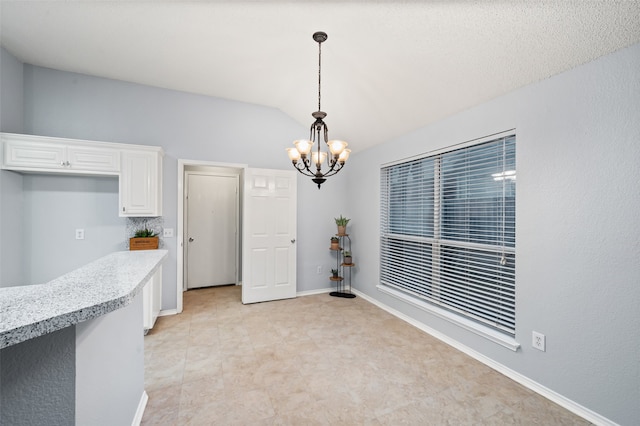 dining room with lofted ceiling, a chandelier, and baseboards