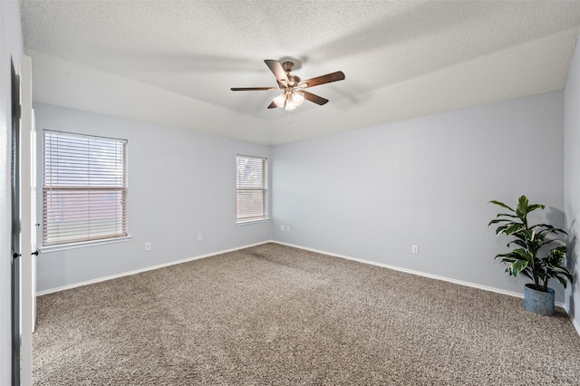 unfurnished room with a textured ceiling, ceiling fan, carpet flooring, and baseboards