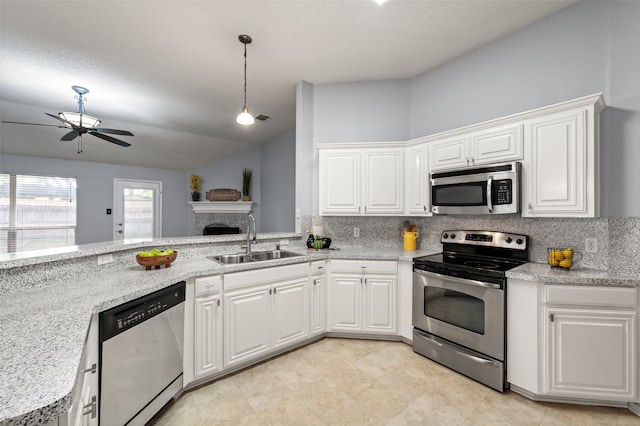 kitchen featuring a sink, stainless steel appliances, ceiling fan, tasteful backsplash, and lofted ceiling