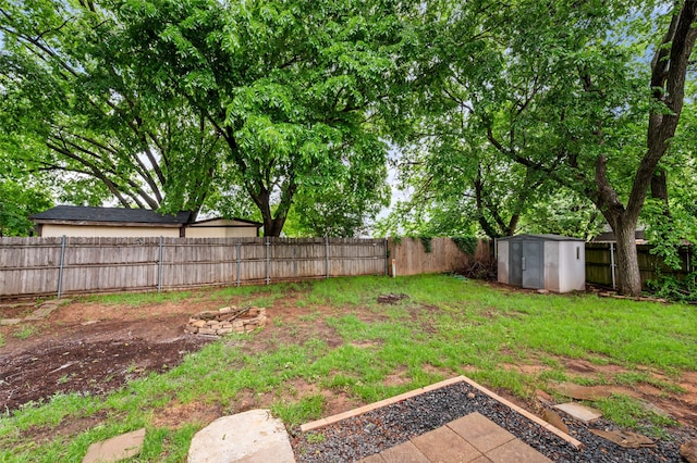 view of yard with an outbuilding, a shed, and a fenced backyard