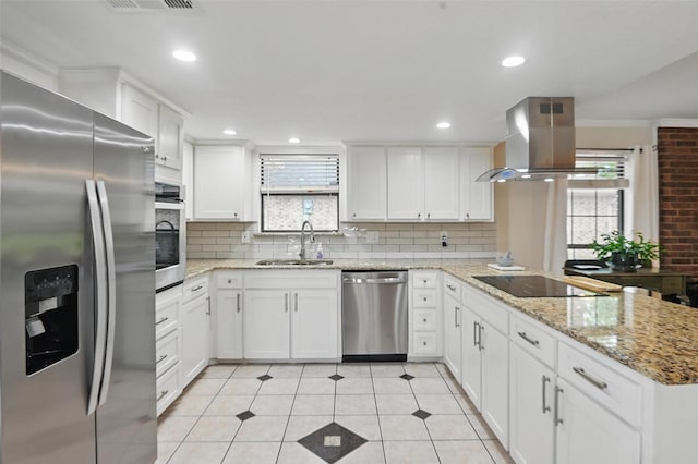 kitchen featuring stainless steel appliances, backsplash, a sink, island exhaust hood, and a peninsula