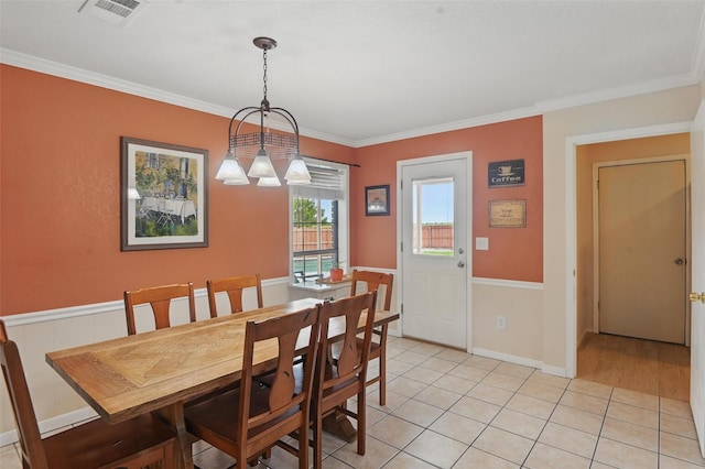 dining space with light tile patterned flooring, visible vents, and crown molding