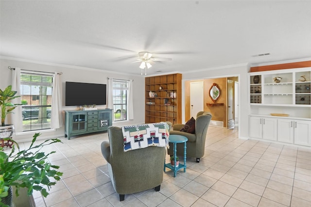 living area with light tile patterned floors, crown molding, visible vents, a ceiling fan, and built in shelves