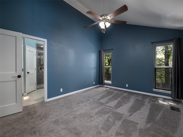 carpeted spare room featuring visible vents, ceiling fan, high vaulted ceiling, and a healthy amount of sunlight