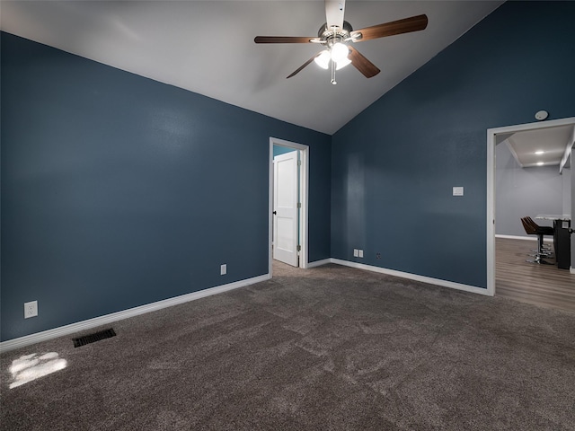 spare room featuring dark colored carpet, ceiling fan, baseboards, visible vents, and high vaulted ceiling